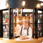 Freundlicher Mitarbeiter im nostalgischen Shopbereich mit Souvenirs