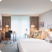 Helles Doppelzimmer mit Schreibtisch und gemütlicher Sitzecke